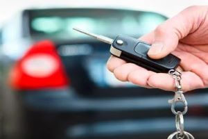 Hand Holding Keys to a Car