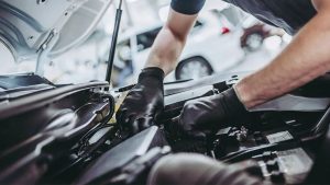Mechanic Checking Under the Hood of a Car